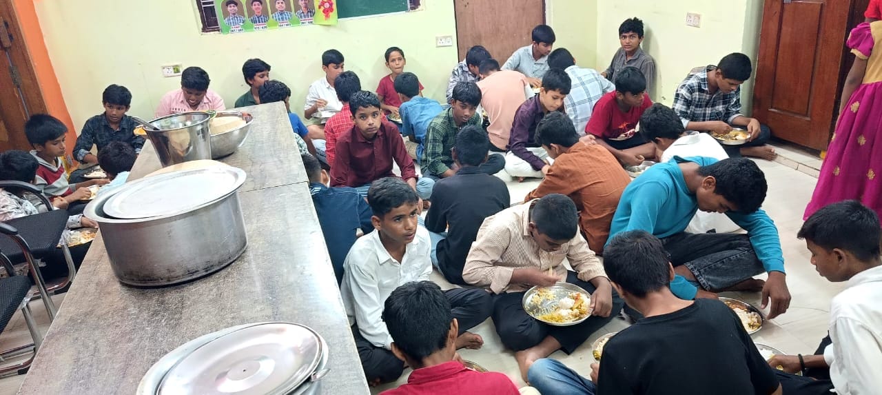 Children with hands folded in gratitude before their meal
